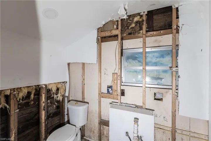 Bathroom featuring toilet and vaulted ceiling