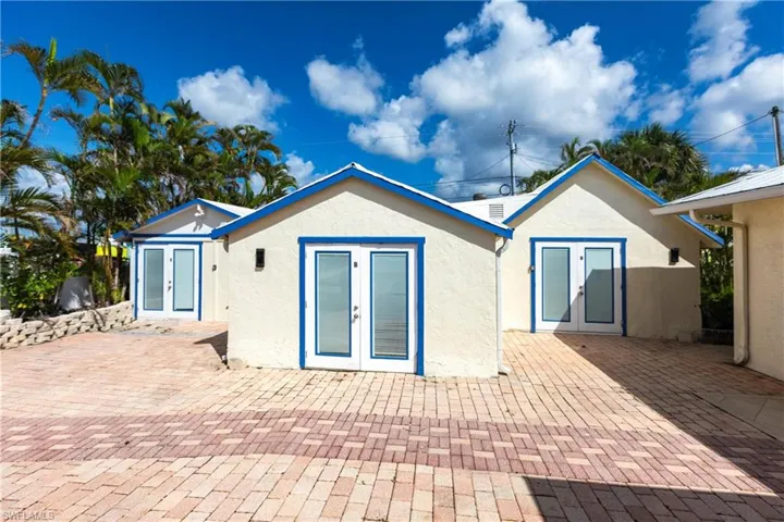 Back of property with french doors, stucco siding, and a patio