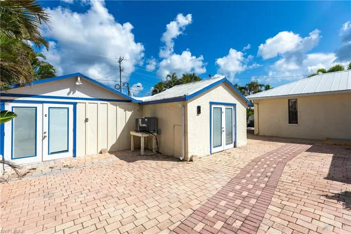 Back of property with french doors, a patio area, stucco siding, and a metal roof