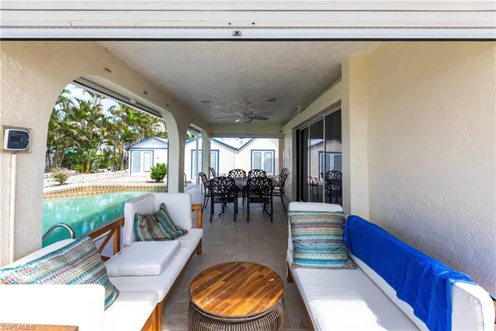 View of patio featuring an outdoor hangout area, outdoor dining space, a ceiling fan, and a storage unit
