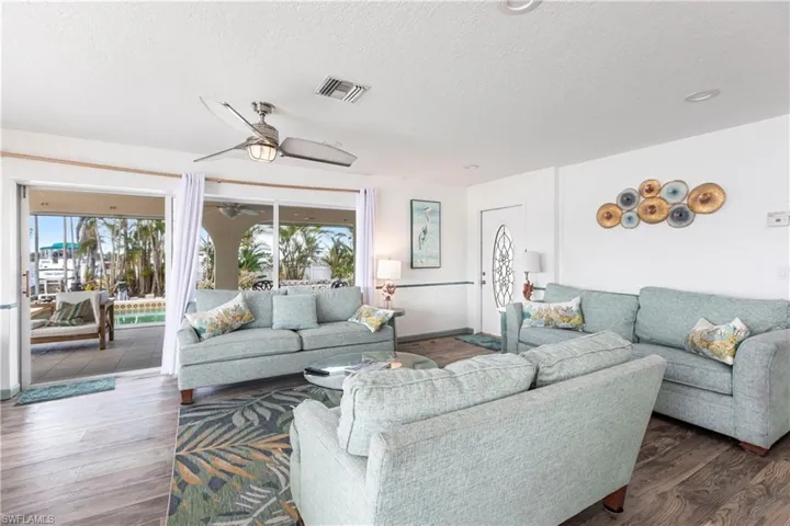 Living room with wood finished floors, a textured ceiling, and ceiling fan