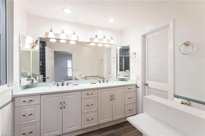 Full bath featuring double vanity and wood finished floors