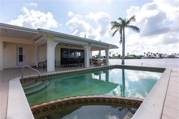 Swimming pool with a water view and a patio area