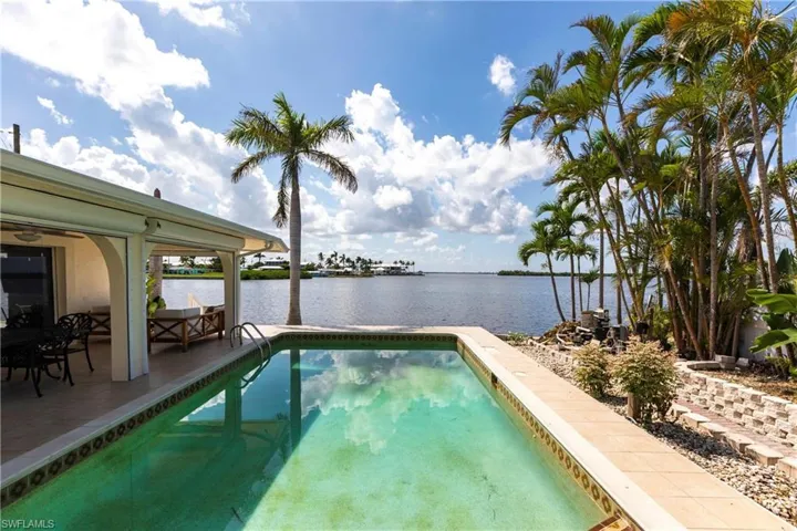 Swimming pool featuring a water view and a patio