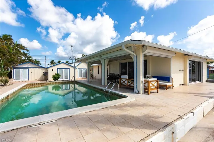 Swimming pool featuring a patio, an outdoor structure, an outdoor living space, and an exterior structure