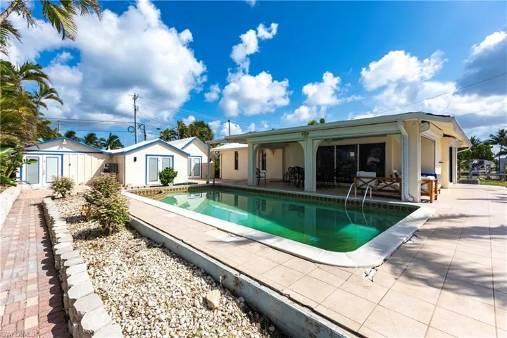 Swimming pool featuring a patio area and an outbuilding