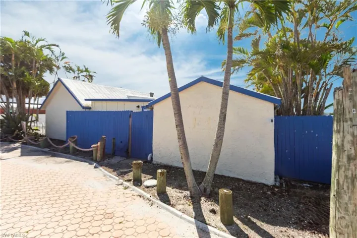 View of side of property featuring a gate and stucco siding