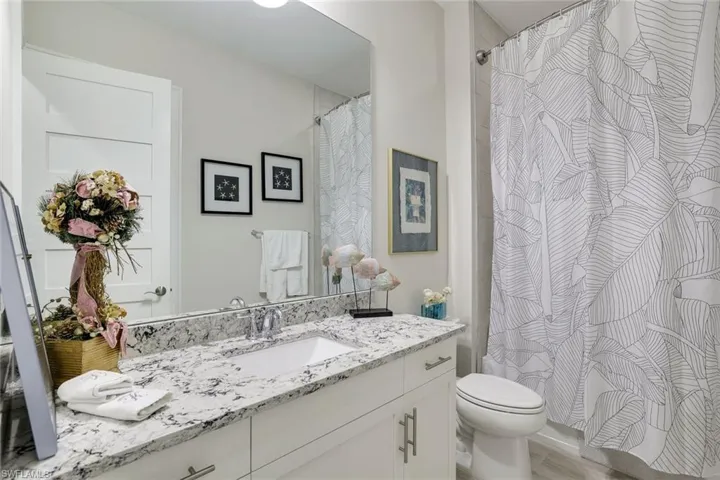 Bathroom featuring vanity, wood-type flooring, and toilet