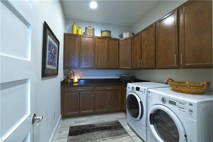 Washroom featuring light hardwood / wood-style floors, cabinets, and separate washer and dryer