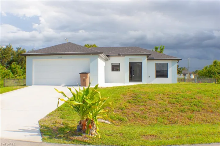 Contemporary single-story residence featuring a dark shingle roof, a two-car garage, and a concrete driveway