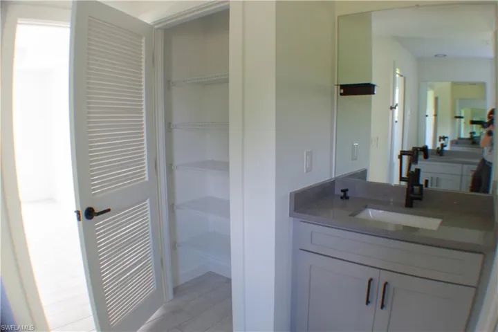 Bathroom vanity with a rectangular undermount sink, gray countertop, and matte black faucet