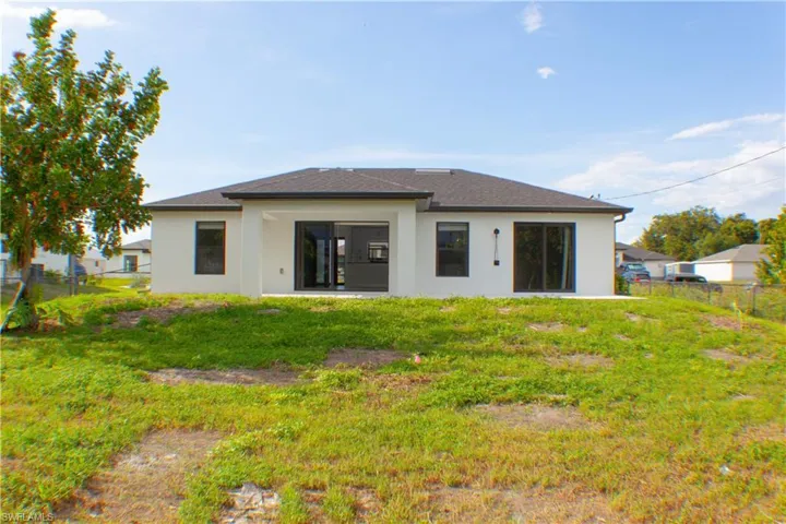 Contemporary rear exterior with white stucco finish and a dark shingle roof