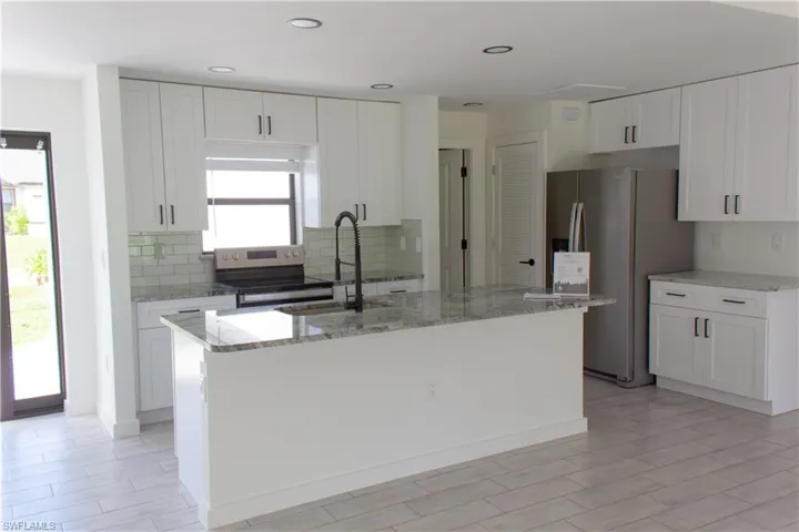 Modern kitchen featuring white shaker cabinetry, stainless steel appliances, a white subway tile backsplash, recessed lighting, and light-toned wood-finish flooring