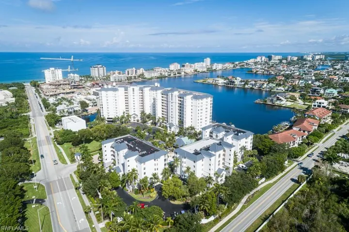 Aerial view of property and surrounding area with a large body of water, apartment complex / building, and nearby urban area