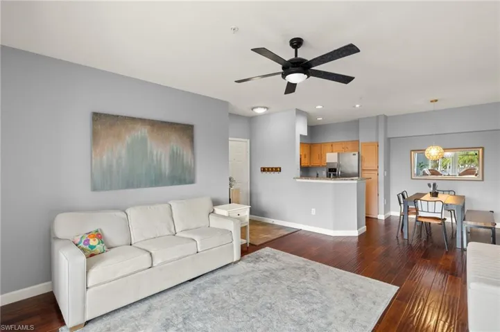 Living area with dark wood-style flooring, a ceiling fan, and recessed lighting