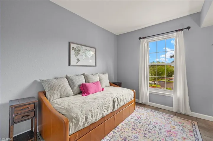 Tiled bedroom featuring baseboards