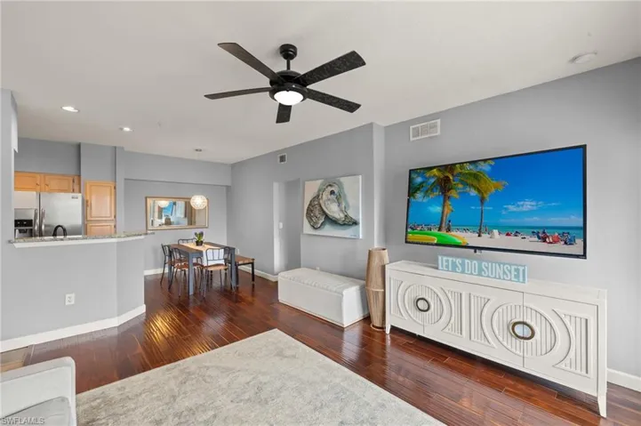 Living area with dark wood-type flooring, a ceiling fan, and recessed lighting