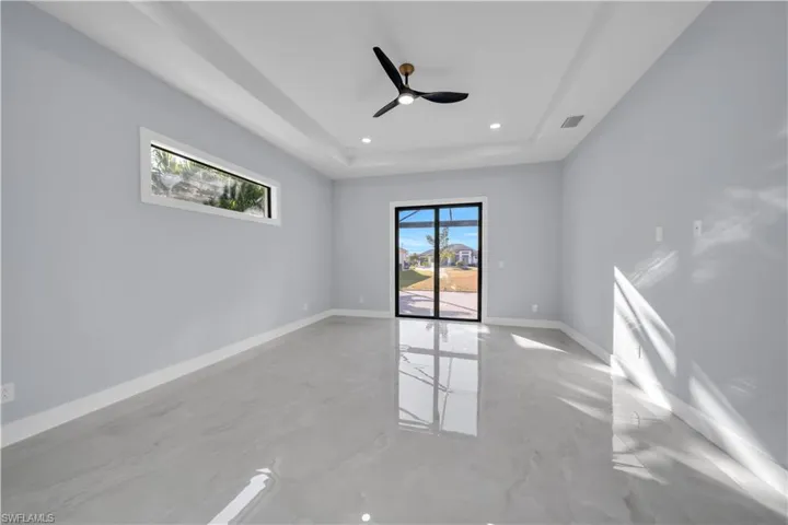 Empty room featuring a tray ceiling, a ceiling fan, and recessed lighting