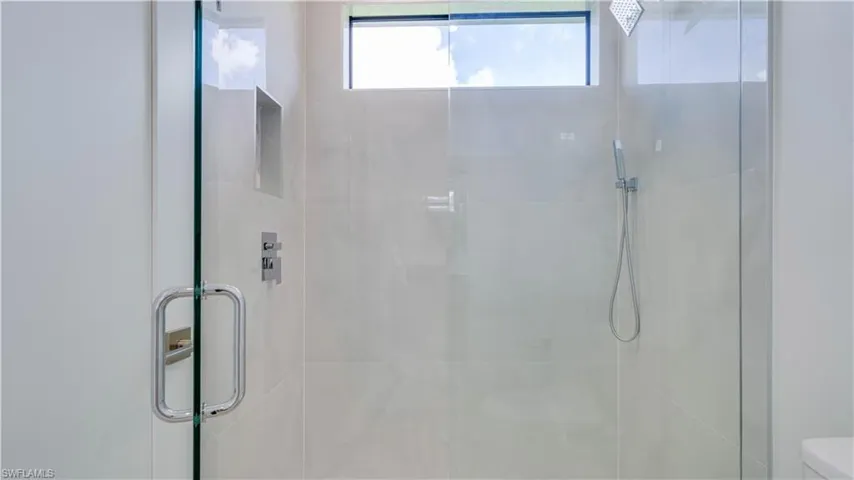Cabana bath walk-in shower with multiple shower heads.