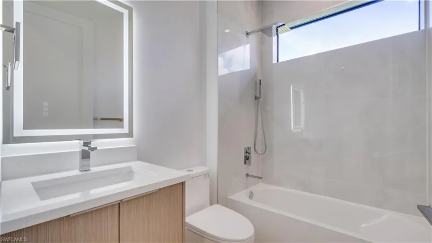 Guest bathroom (3rd bathroom) with backlit mirror and multiple shower heads.
