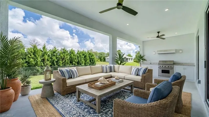 Large open lanai with tile flooring, ceiling fans and custom lighting. Virtually staged/enhanced.