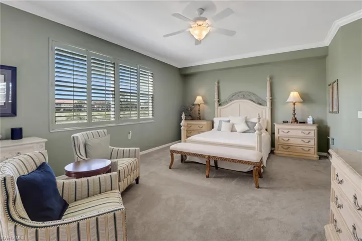 Carpeted bedroom with ornamental molding and ceiling fan