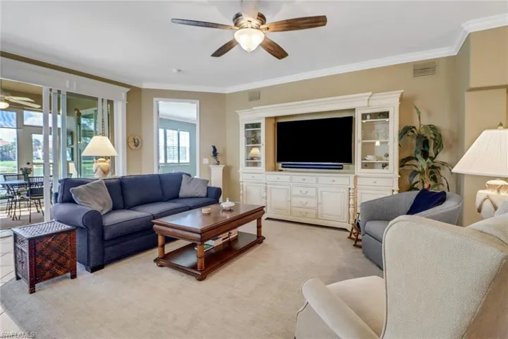 Living room featuring ornamental molding and ceiling fan