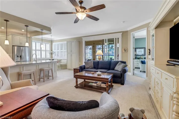 Tiled living room featuring crown molding, ceiling fan, and sink