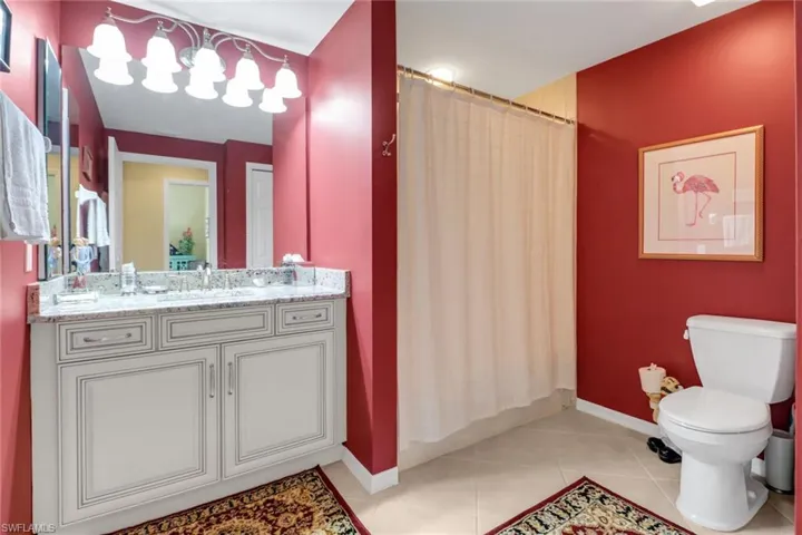 Bathroom featuring tile patterned flooring, vanity, a shower with curtain, and toilet