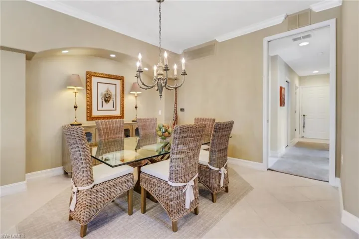Dining room with an inviting chandelier, light tile patterned floors, and ornamental molding