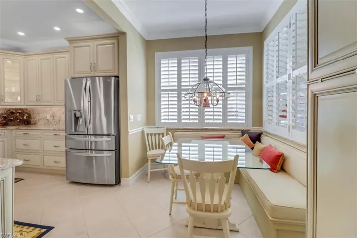 Dining room featuring ornamental molding, light tile patterned floors, and a notable chandelier