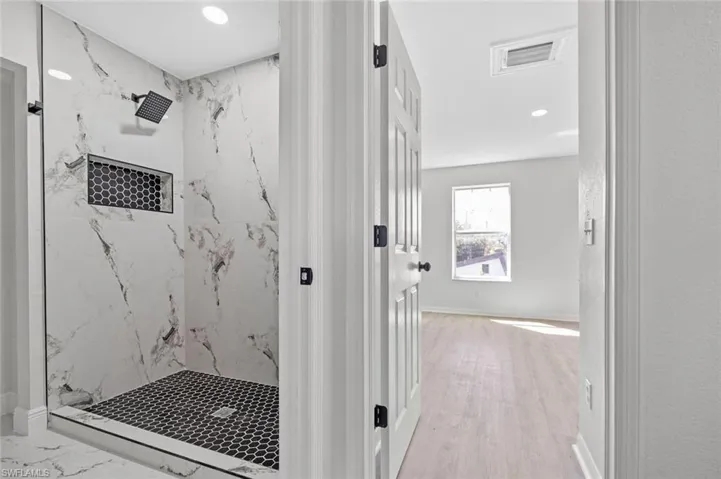 Bathroom featuring a marble finish shower and recessed lighting