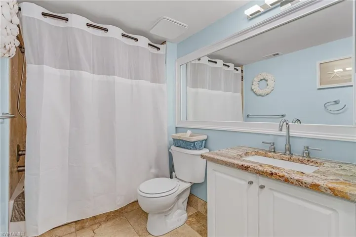 Full bathroom featuring shower / bath combo, vanity, and light tile patterned flooring