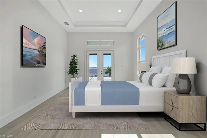 Bedroom featuring french doors, access to outside, light wood finished floors, a raised ceiling, and recessed lighting
