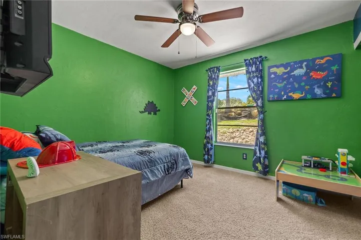 Bedroom with ceiling fan and carpet