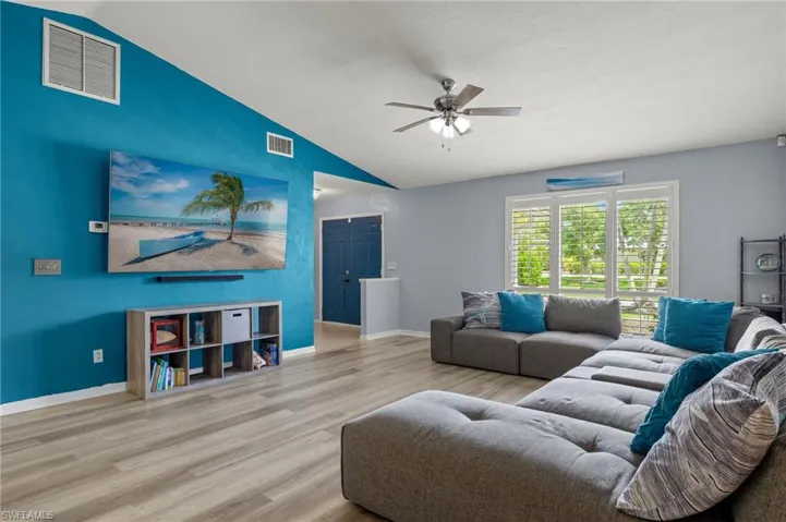 Living room featuring lofted ceiling, light hardwood / wood-style flooring, and ceiling fan
