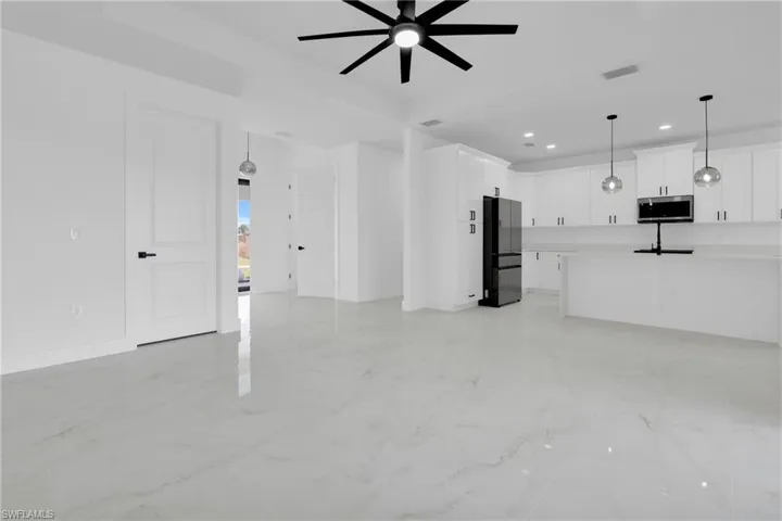 Unfurnished living room featuring recessed lighting, ceiling fan, and light marble finish floors