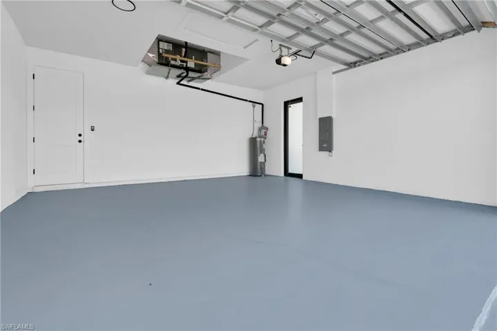Garage featuring water heater and electric panel