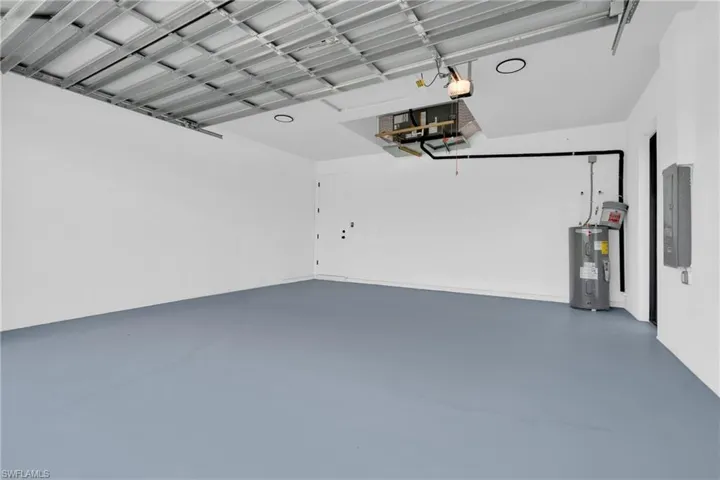 Garage featuring electric water heater and electric panel