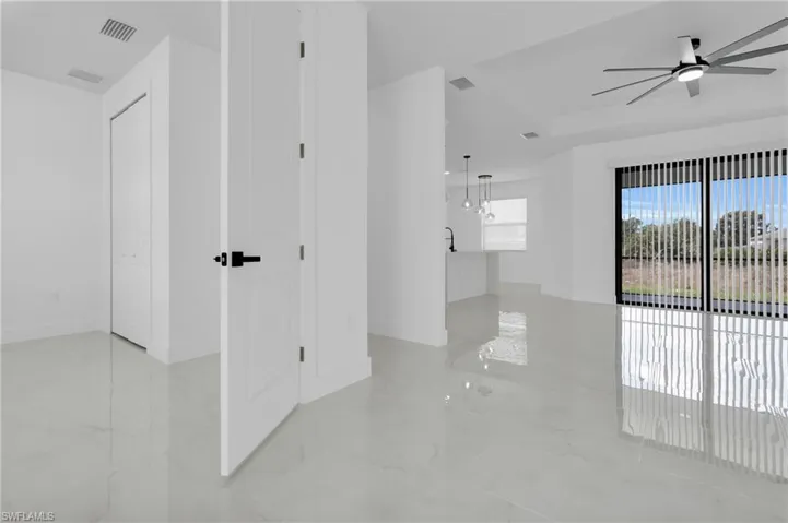 Unfurnished bedroom, featuring ceiling fan and light marble finish flooring, view of kitchen, Dinning Room and Living, view of porch lanai.