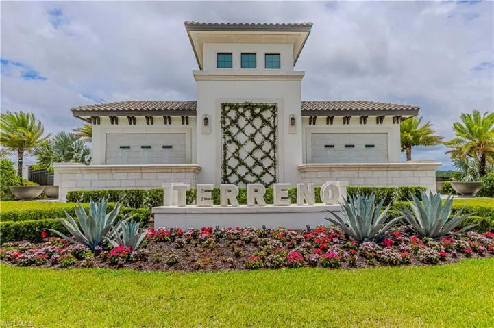 View of front of property with a tiled roof, stucco siding, and a front yard