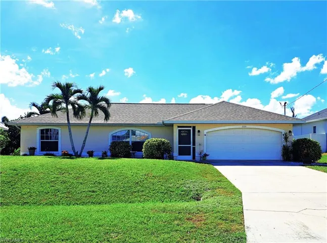 Ranch-style home with a garage and a front lawn