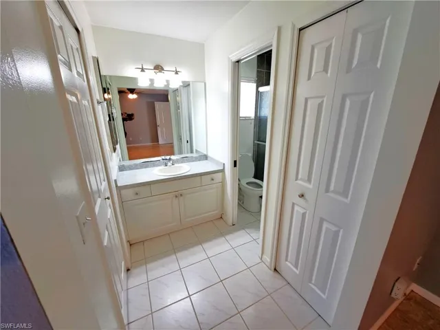 Master Bath vanity featuring tile patterned flooring, vanity, ceiling fan, and toilet