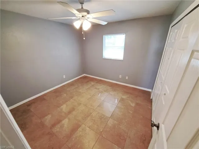 Unfurnished bedroom with ceiling fan and a closet