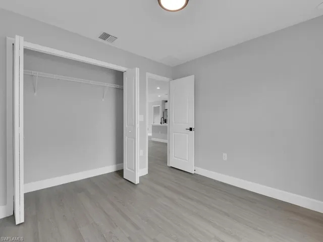 Unfurnished bedroom with light hardwood / wood-style floors and a closet