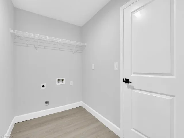 Laundry room with electric dryer hookup, hookup for a washing machine, and light hardwood / wood-style floors