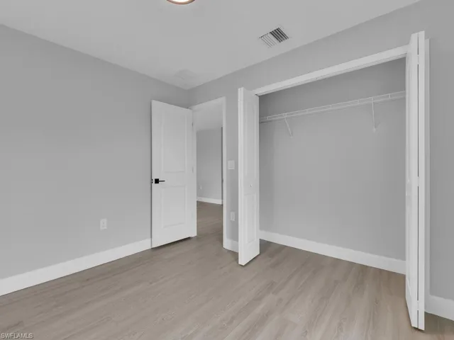 Unfurnished bedroom with light hardwood / wood-style flooring and a closet