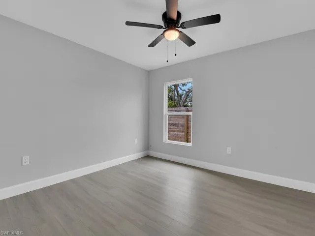 Empty room with ceiling fan and light wood-type flooring