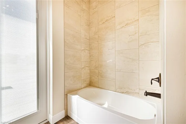 Bathroom with a bathtub and baseboards