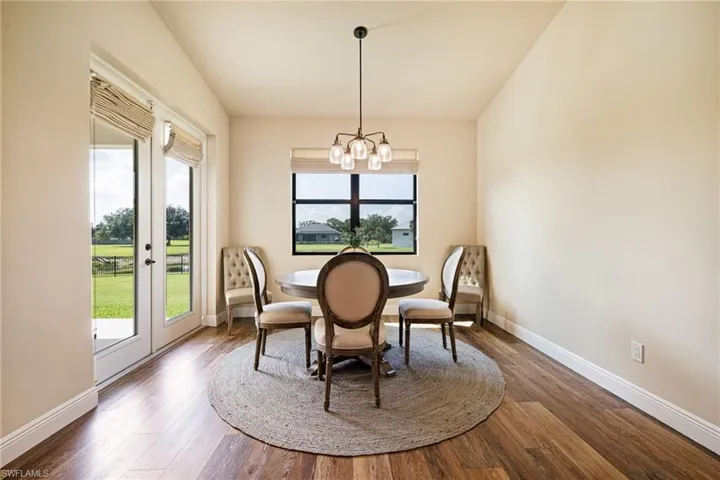 Dining space featuring a chandelier, baseboards, wood finished floors, and lofted ceiling